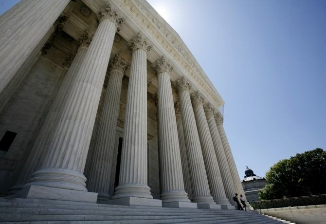 People walk down the steps of the Supreme Court