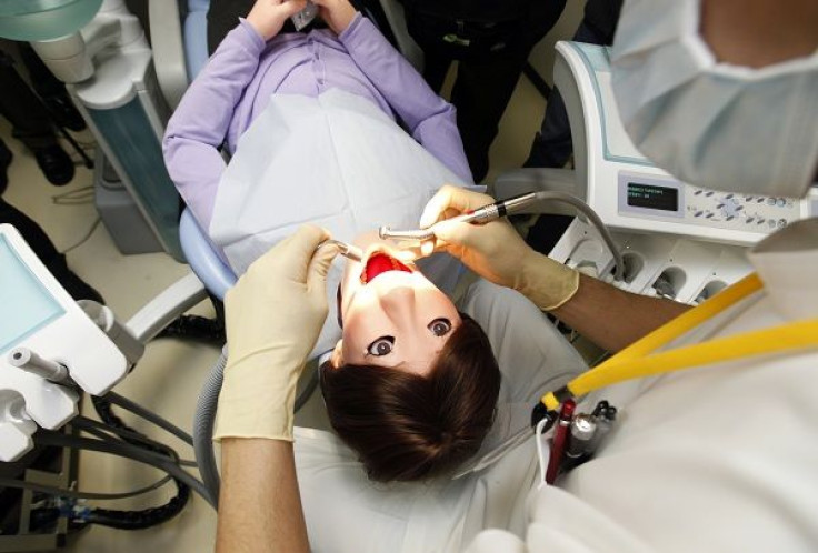 A dentist demonstrates on a dental patient robot at its unveiling ceremony at Showa University in Tokyo March 25, 2010