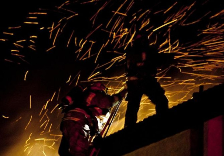 Firefighters work to extinguish a multiple alarm fire at an apartment complex in Pasadena, California in the early morning December 1, 2011.