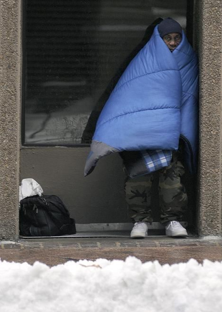 Ted Devon who is homeless and could not get into a shelter tries to stay warm along an icy Peachtree Street after a snow carpeted the Deep South in Atlanta, Georgia, January 10, 2011.