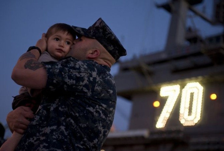 A soldier says goodbye to his family before deployment.