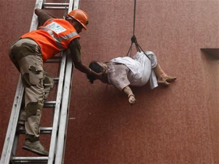A fire fighter evacuates a patient from a hospital after it caught fire in Kolkata December 9, 2011.