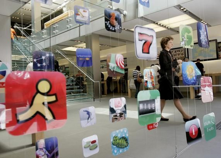 A woman walks past icons for Apple applications at the company's retail store in San Francisco, California April 22, 2009.