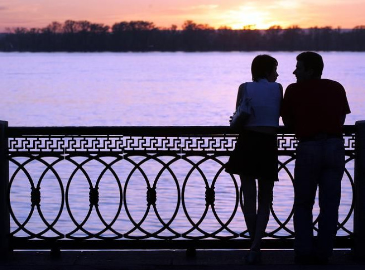 A couple stands at the embankment of the Volga River