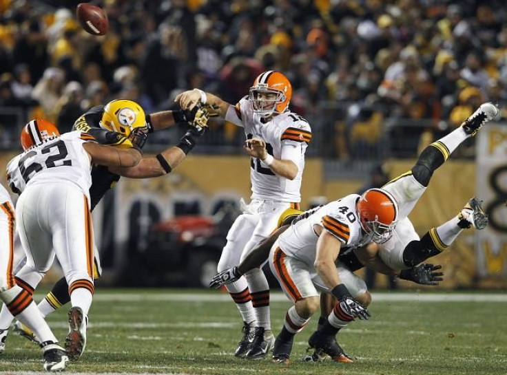 Cleveland Browns quarterback Colt McCoy (12) gets a pass off before Pittsburgh Steelers' Brett Keisel (L) can sack him in the second quarter of their NFL football game in Pittsburgh, Pennsylvania, on December 8, 2011.