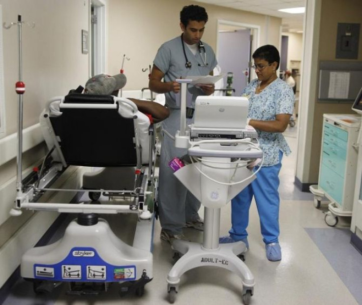 Hussain Gilani, Resident M.D. (C) reads over a patients electrocardiogram results in the hallway of the emergency room at Ben Taub General Hospital in Houston, Texas, July 27, 2009.