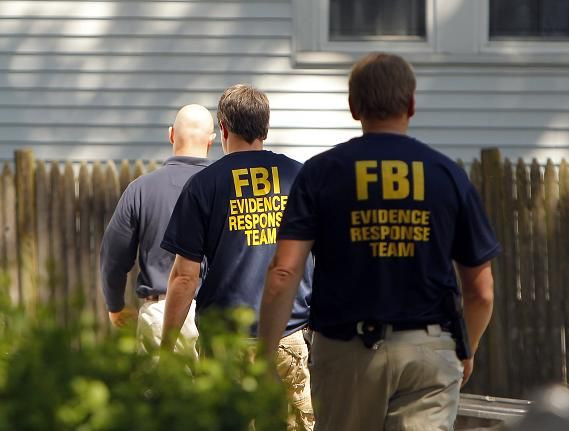 FBI agents are seen outside 39 Waverly Avenue, where earlier in the day they raided the home in Watertown, Massachusetts May 13, 2010.