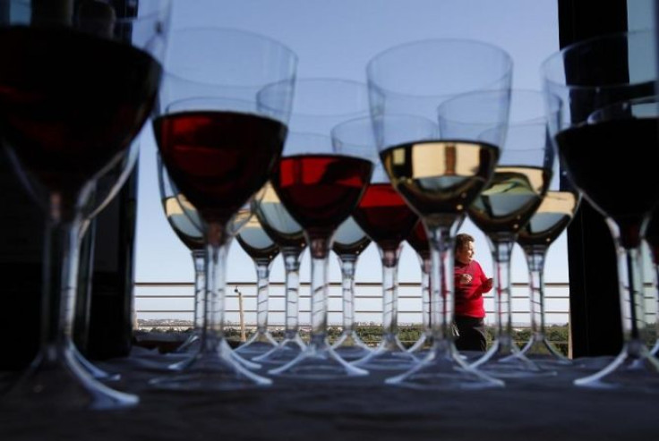 A woman attends the Vivanda Taste the Med food festival as glasses of red and white wine are placed on a display table at Ta' Qali, outside Valletta November 6, 2011.