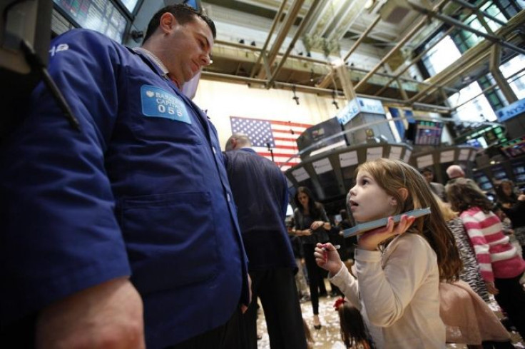 Trader Mike Sciulli talks with his daughter on the floor of the New York Stock Exchange during the NYSE's annual kids day November 25, 2011.