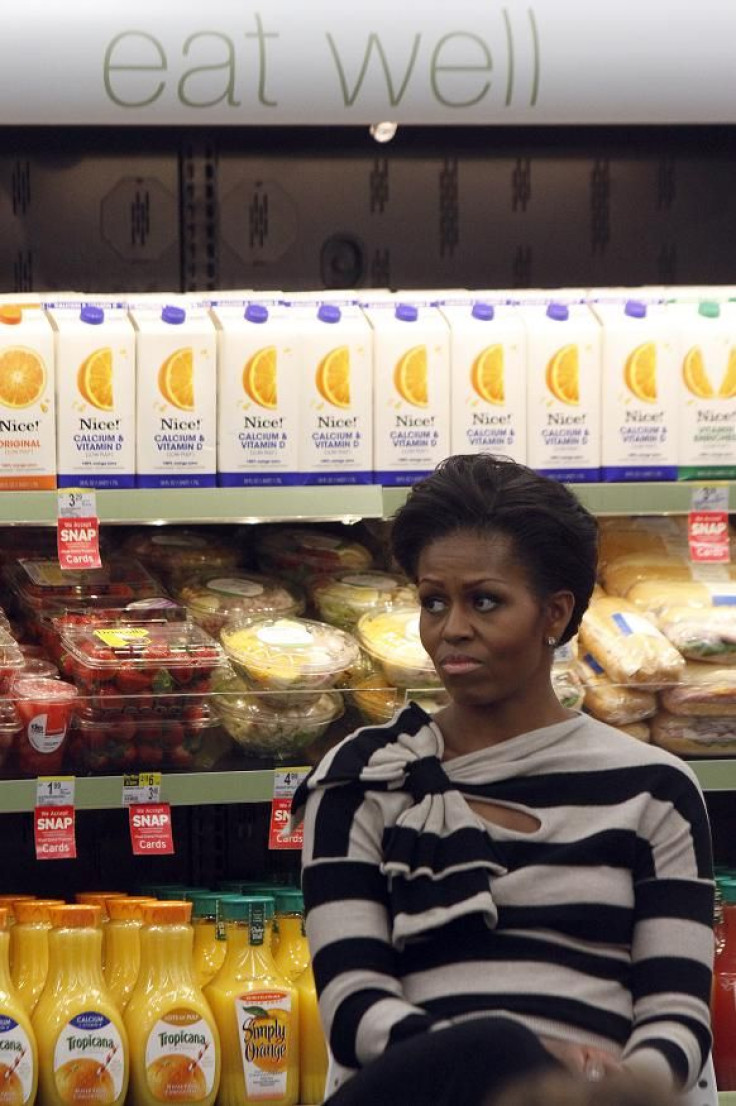 U.S. first lady Michelle Obama listens to Chicago Mayor Rahm Emanuel during an appearance at a Walgreens store Chicago's Englewood neighborhood October 25, 2011.