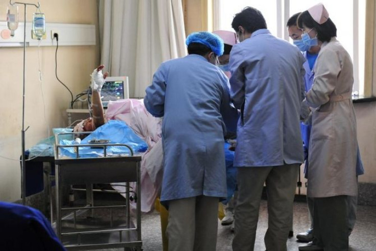 An injured man raises his hand as he receives treatment at a hospital in Xi'an, Shaanxi province November 14, 2011.