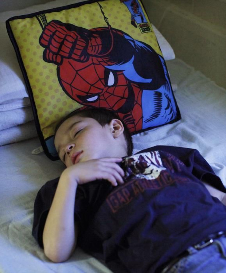 Ronaldo Rios, son of Laura Rios, sleeps on his mother's bed at his homeless shelter in New York, December 21, 2011.