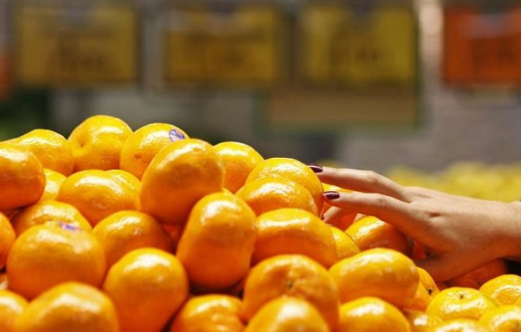 A woman picks up some mandarin oranges at a fruits shop June 7, 2011.