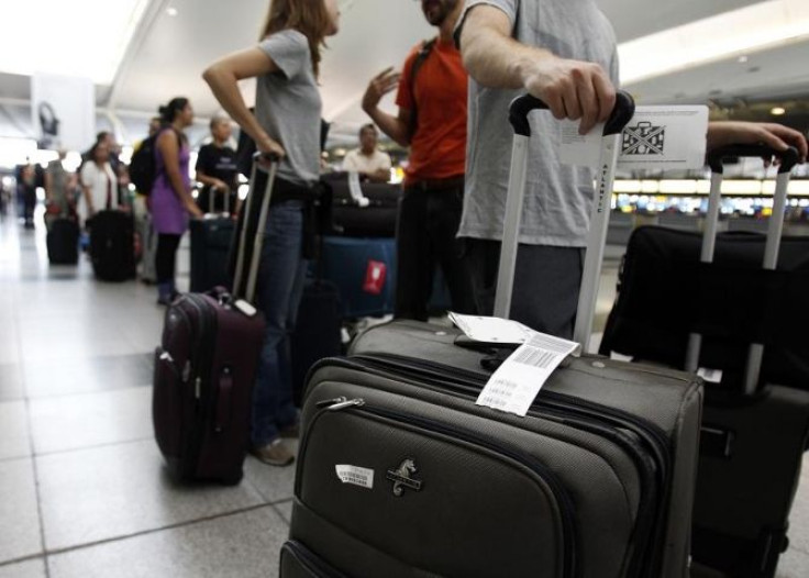 Passengers wait in line to depart JFK International Airport in New York August 27, 2011