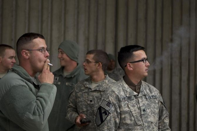 Soldiers from the 3rd Brigade, 1st Cavalry Division smoke cigarettes outside an airport in Bangor, Maine December 21, 2011 during a layover on a flight from Kuwait that will take the unit back to Fort Hood in the United States.