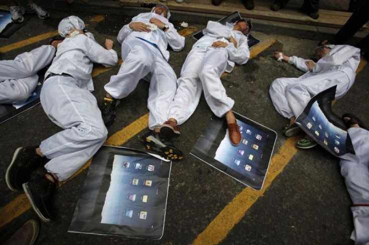 Local and mainland Chinese university students, in the role of Foxconn workers, lie on the floor as they act out being chemically poisoned during a street drama in Hong Kong May 7, 2011.