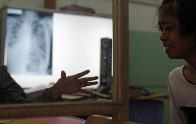 A doctor (L) comforts her tuberculosis patient at the Indonesian Union Against Tuberculosis clinic in Jakarta, April 4, 2011.