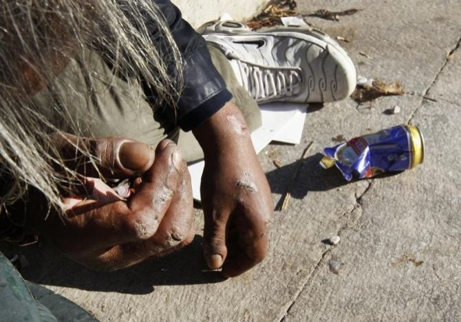 A drug addict holds a syringe with narcotics in central Athens January 13, 2012.