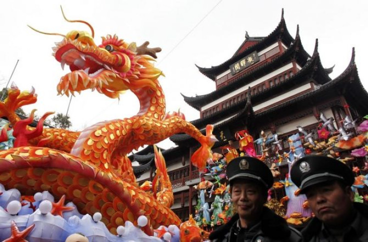 Security guards walk past a dragon lantern among other Chinese New Year decorations at Yuyuan Garden in downtown Shanghai January 17, 2012.