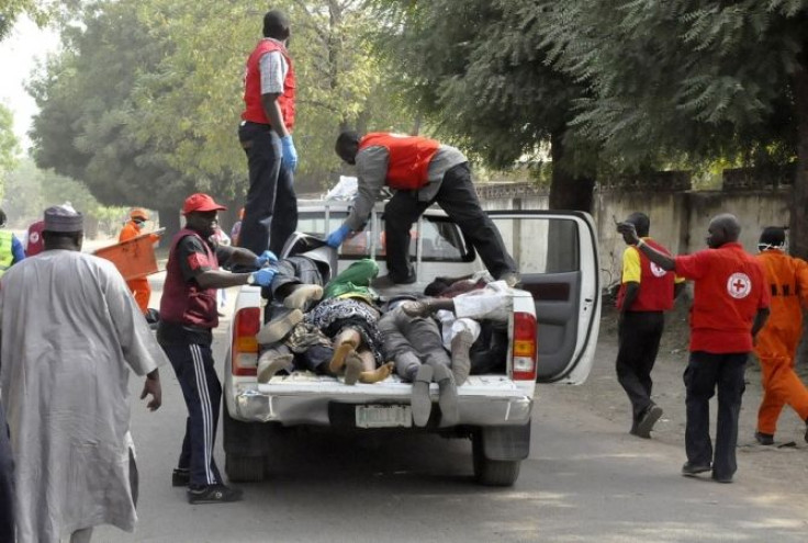 Red Cross officials load bodies into a truck