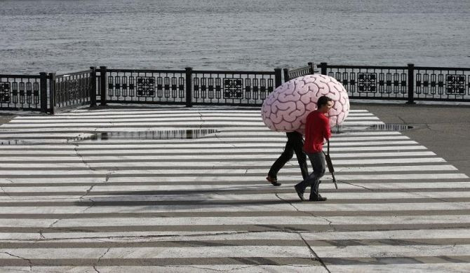 Workers carry a creation by Siberian artist Vasily Slonov named "Brain on crutches. State intellectual project Skolkovo" from the Museum of Modern Art during the ninth Krasnoyarsk museum biennial in Russia's Siberian city of Krasnoyarsk Septembe