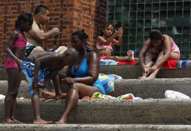 People apply sunscreen while sitting on the steps next to the Astoria Park Pool in New York July 21, 2011.