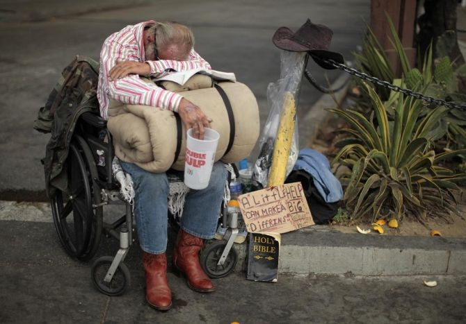 A homeless man begs for money in downtown Los Angeles.