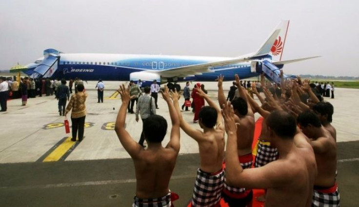 Indonesian dancers perform near a brand new Boeing 737-900 ER series in Jakarta.