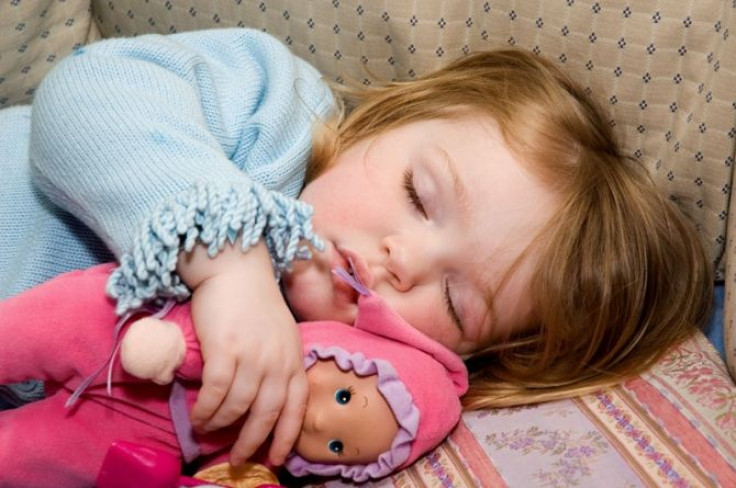 A girl asleep with her doll.