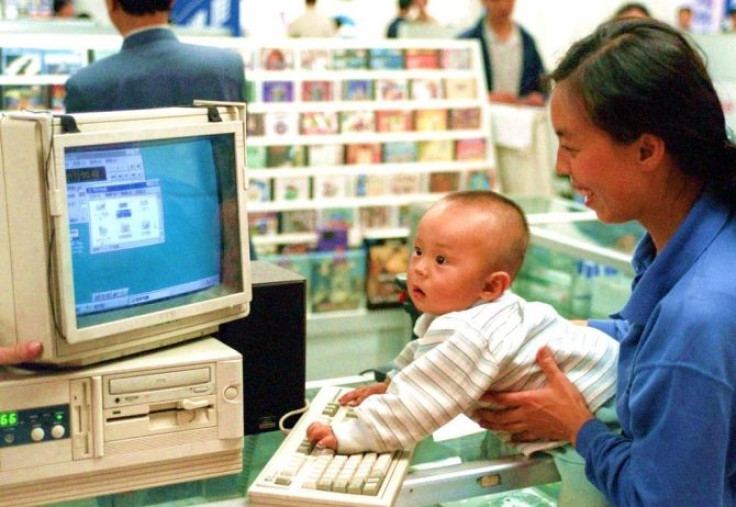 A mother, visiting a store in Beijing's computer district of Haidian, introduces her baby to a display model April 29.