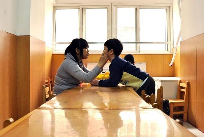 An autistic child learns to speak next to his teacher