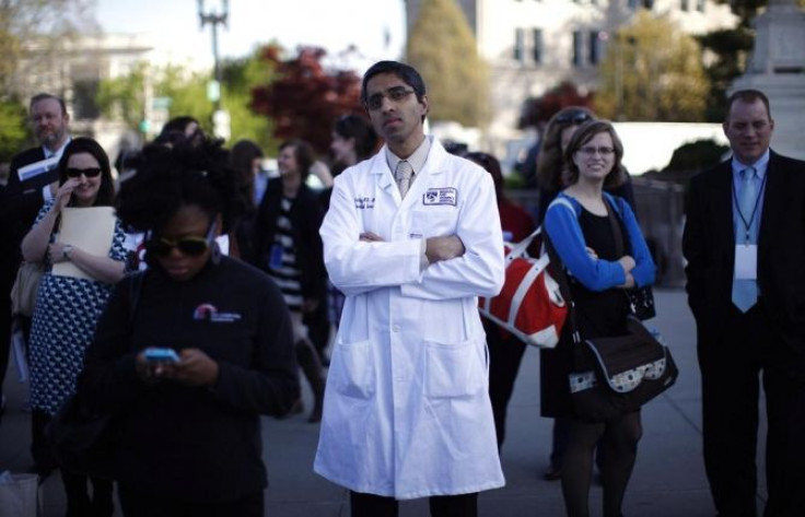 Doctor Vivek Murthy stands among other bystanders during the first day of legal arguments over the Affordable Care Act outside the Supreme Court in Washington March 26, 2012.