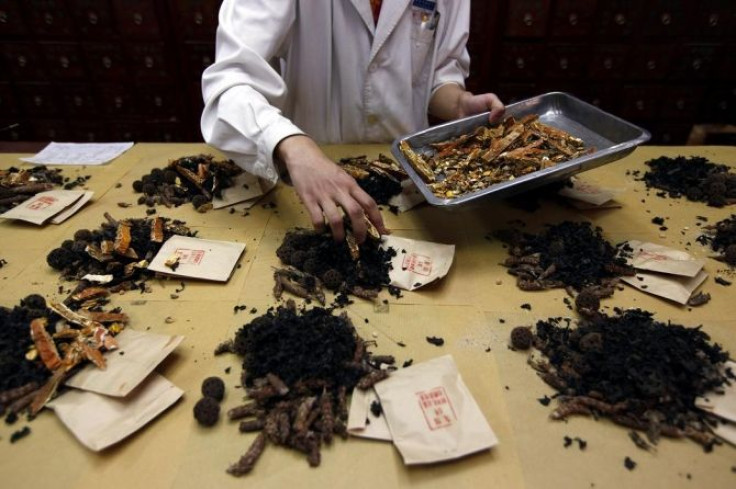 A worker prepares traditional Chinese herbal medicines at Beijing's Capital Medical University Traditional Chinese Medicine Hospital.