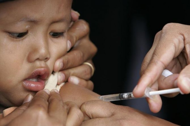 A child looks as a paramedic injects measles vaccine into her arm at Playen district in Gunung Kidul, near the earthquake-hit Indonesian city of Yogyakarta, June 7, 2006.