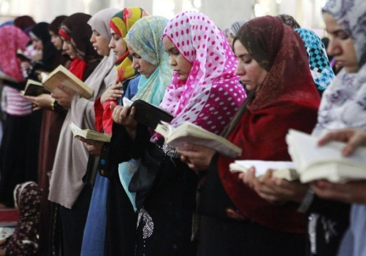 Muslim women hold the Koran as they perform the night prayer at a mosque during the holy month of Ramadan in Cairo