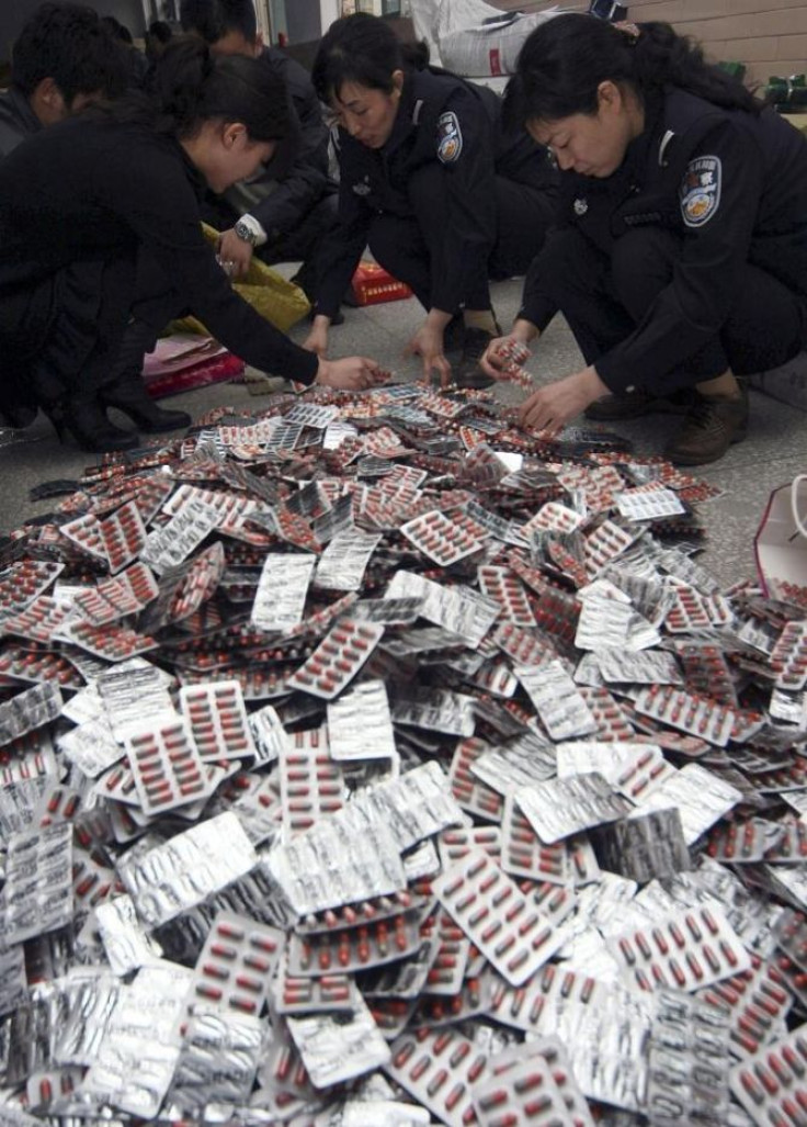 Policemen check confiscated fake drugs after they smashed a counterfeit gang in Xuchang, Henan province, March 18, 2009. Cases involving illegal drugs and medical devices totalled 297,500 in 2008 alone, down almost 10 percent from 329,613 in 2007, accordi