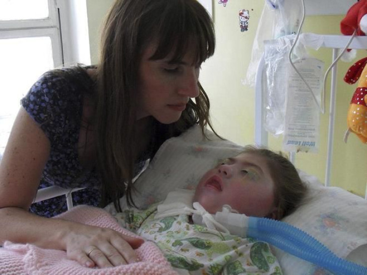 Silvia Herbon nurses her daughter, Camila, who has been in a coma since she was born three years ago and has no brain activity or other vital signs, in Buenos Aires.
