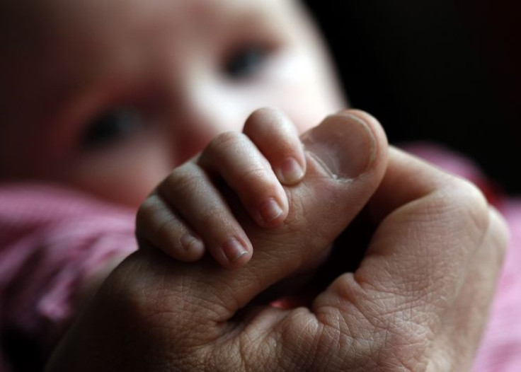 baby holding father's hand