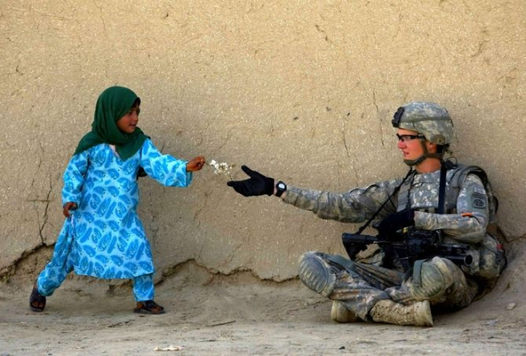 A U.S. soldier receive flowers from an Afghan girl during a patrol in the Arghandab valley in Kandahar province, southern Afghanistan
