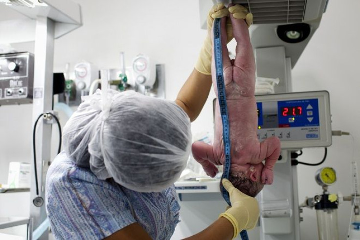 A newborn baby is measured by a nurse minutes after he was born inside the childbirth unit.