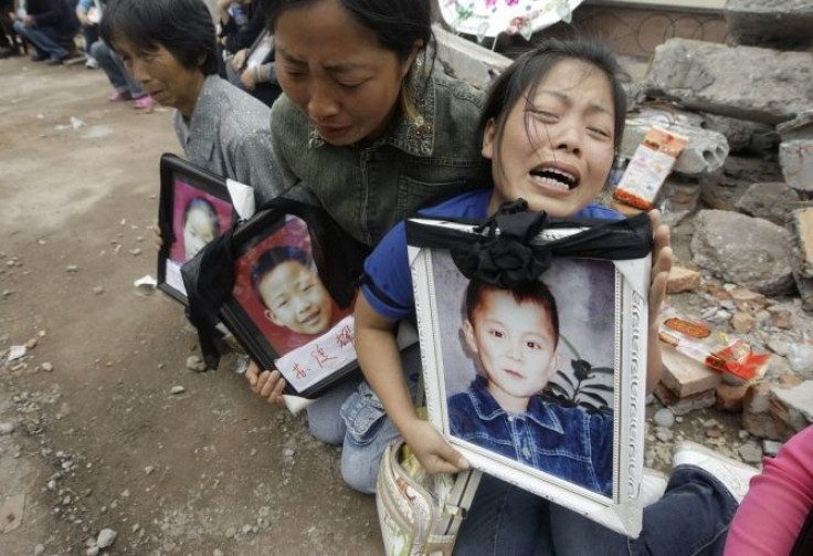 Researchers found that there was a 133 percent increase in the risk of a mother dying within the first two years of the death of a son or daughter. A woman holding a portrait of her 12-year-old son Feng Junwei cries next to the ruins of destroyed Fuxing p