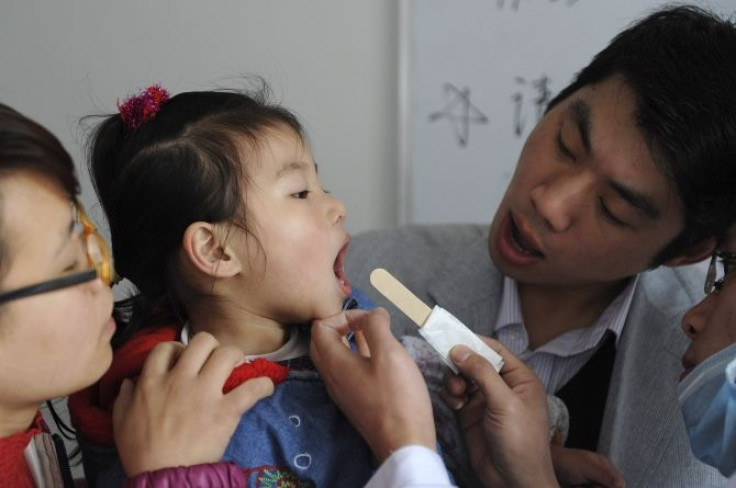 A doctor examines a child for symptoms of hand, foot and mouth (HFMD) disease at a hospital in Hefei