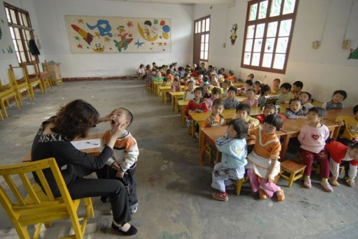 A doctor examines a child for signs of infection from a kind of intestinal virus, identified as enterovirus 71 or EV71, at a kindergarten in Baokang, Hubei province.