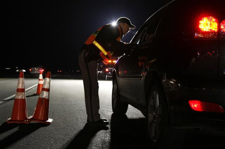 police asks a driver if he has been drinking while smelling for alcohol