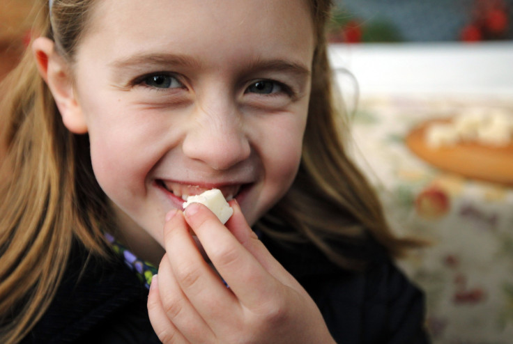 A girl samples a piece of cheese