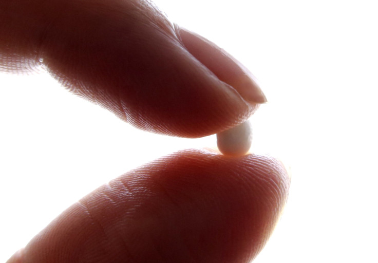 a woman holding a birth control pill