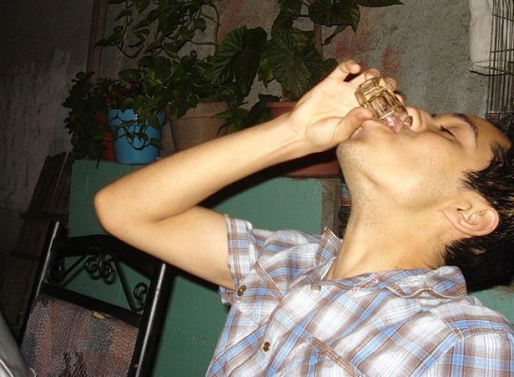 Binge drinker takes a shot of alcohol