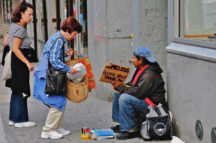 Woman giving money to homeless