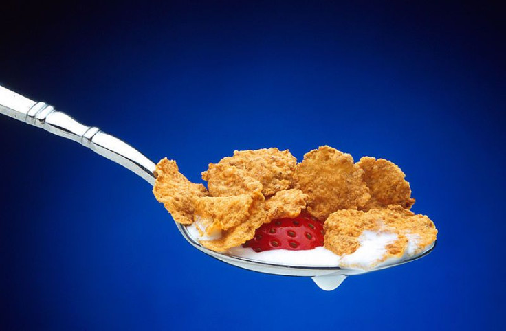 Spoon with strawberries, cereal and milk