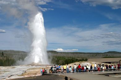 Tourists Watch Old faithful in Yellowstone National Park.